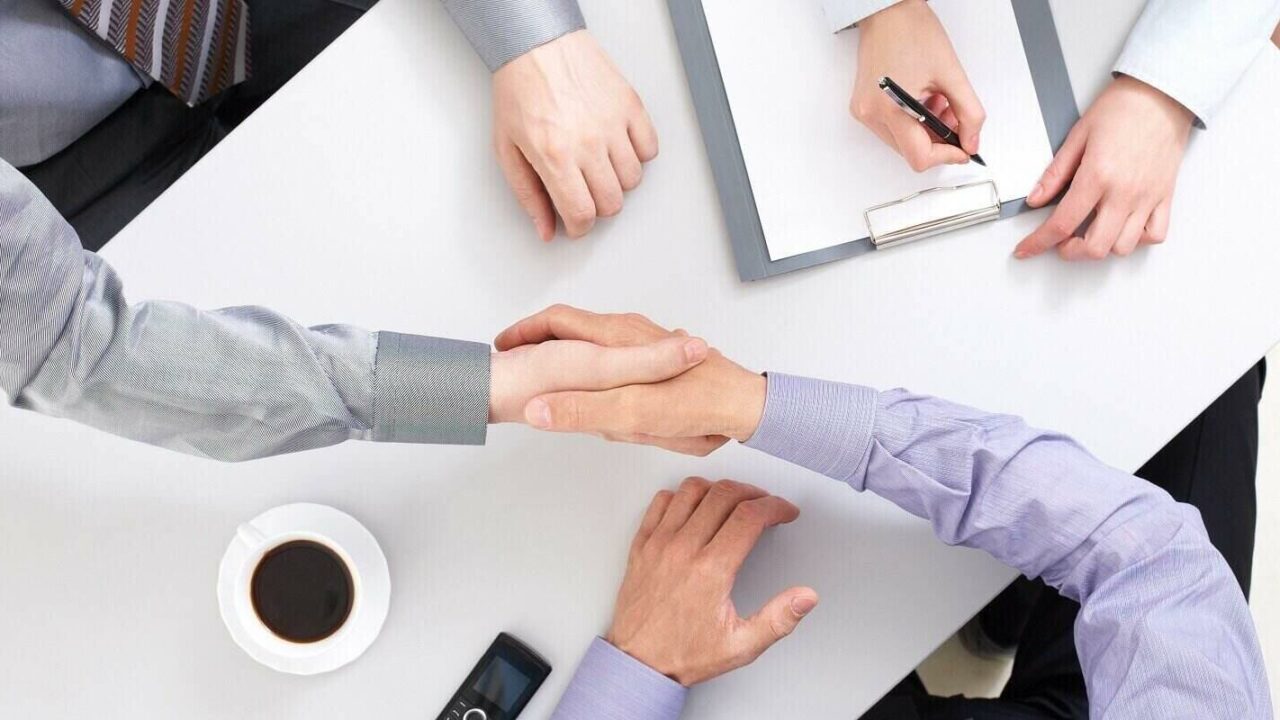 above view of businessmen doing agreement at workplace