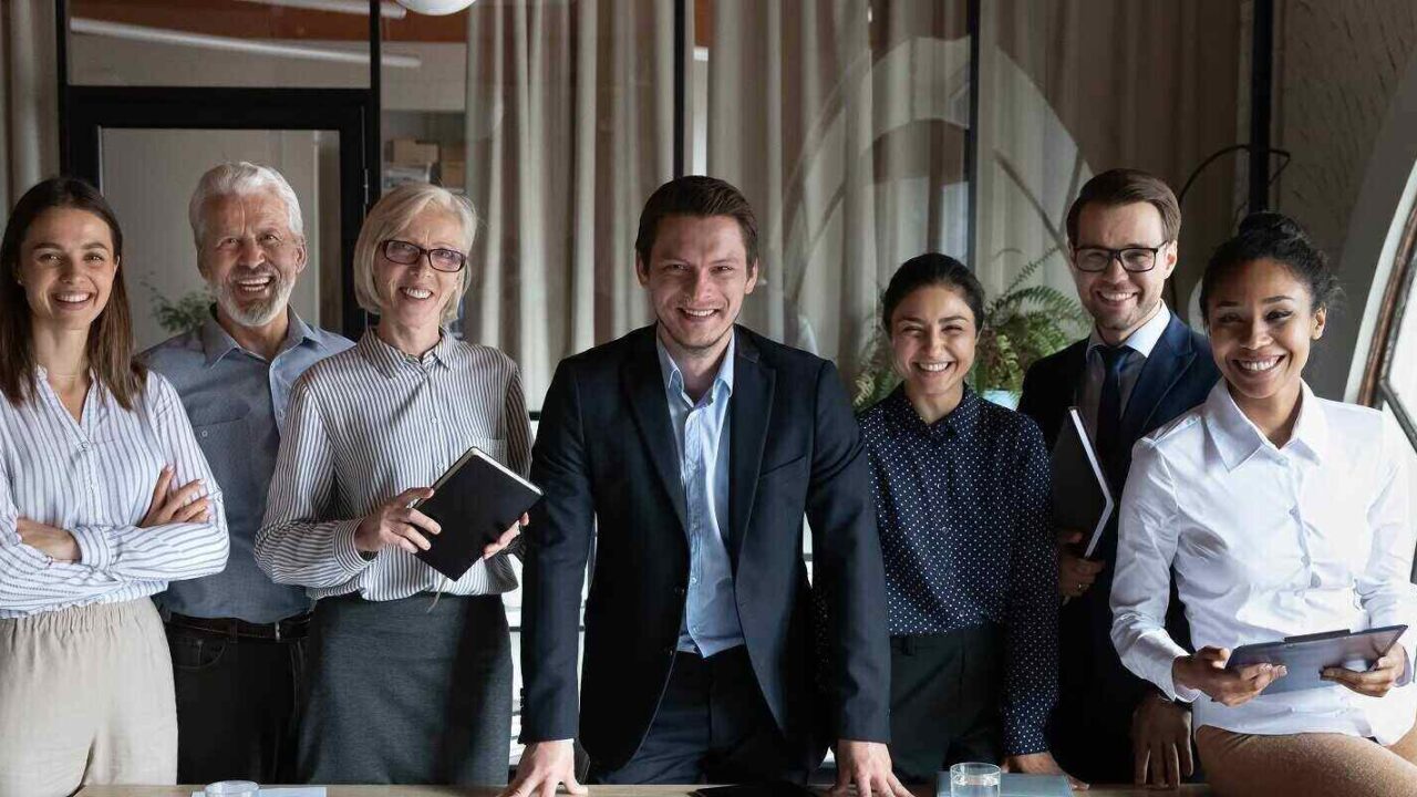 happy multiracial businesspeople stand pose at workplace in modern office