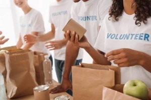 group of volunteers opening food packages with nonprofit insurance