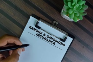 errors & omissions insurance write on a paperwork isolated on wooden table