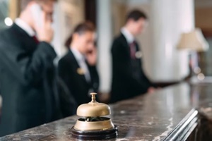 smiling manager in uniform using tablet pc while greeting the guests of the hotel