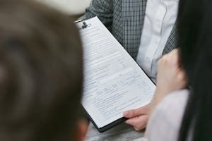 Person Showing Insurance Policy Documents to Clients