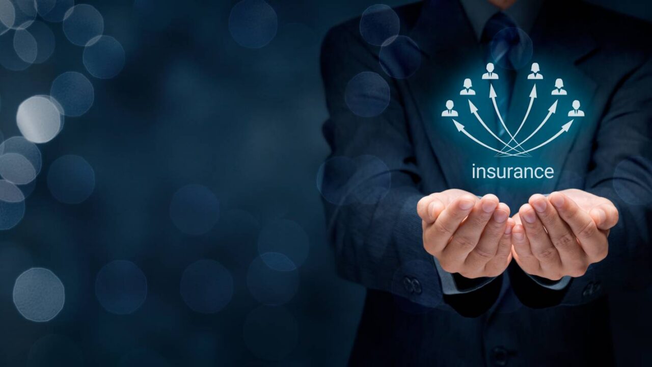 Businessman Putting Hand Below Digital Interface with Insurance Text and Employee Icons