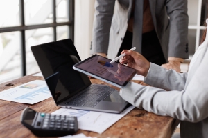 Business People Conducting Business Assessment by Analyzing Charts on Tablet