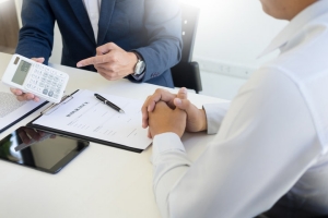 Business Team Evaluating Need of E&O Insurance Using Calculator