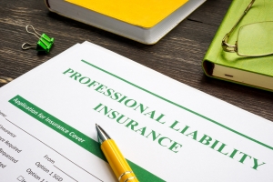 Professional Liability Insurance Documents and Yellow Pen for Signing