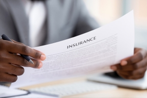 Businessman Reviewing an Insurance Policy Document with a Pen in Hand