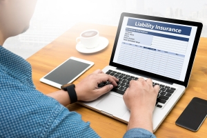 Person Reviewing Liability Insurance Form on Laptop