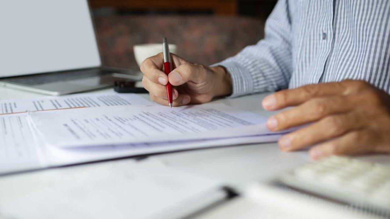Businessman Eeading E&O Insurance Documents on His Desk